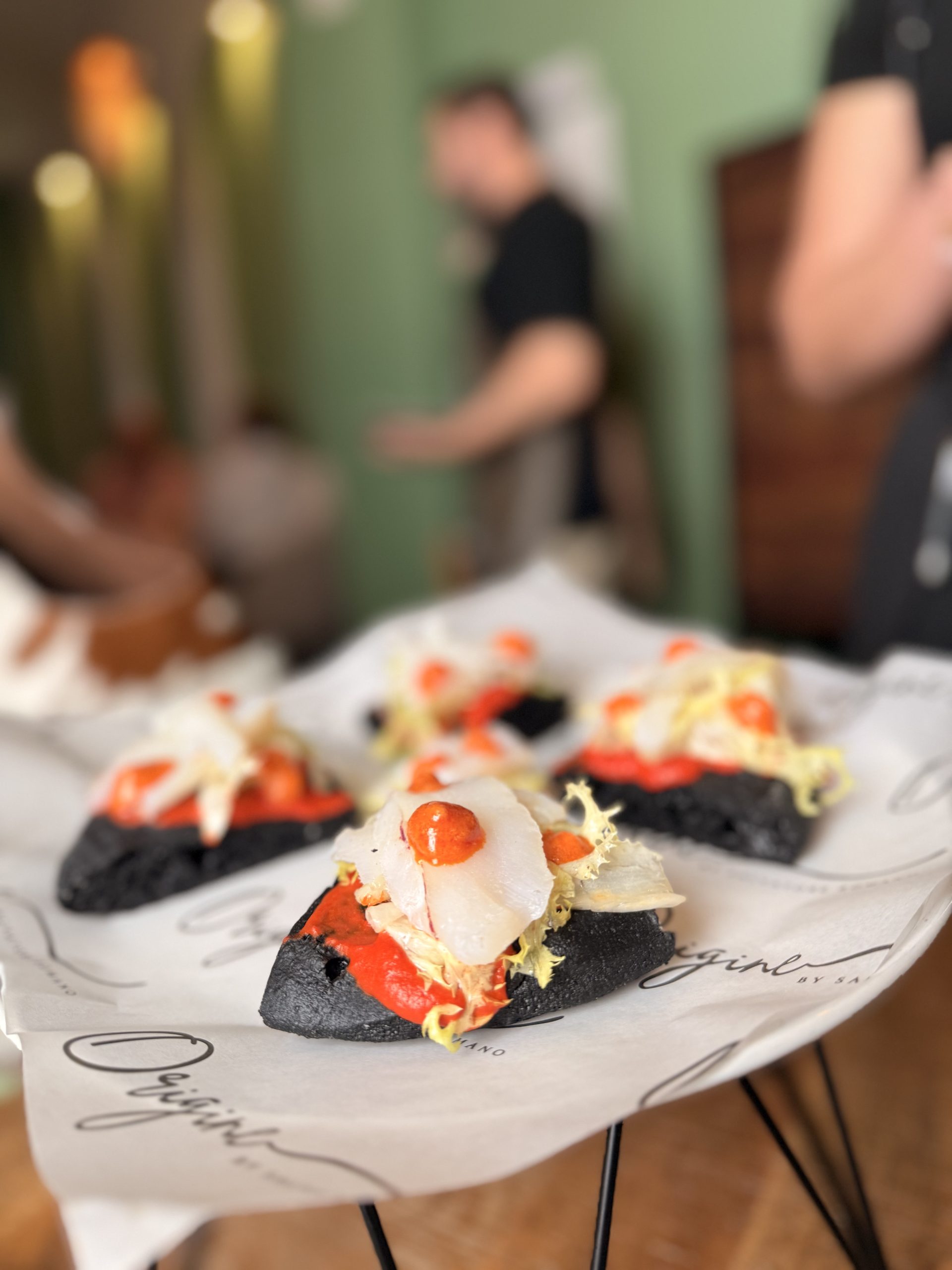 Bakkalà, masa de carbón vegetal, el hummus de pimiento a la brasa, la ventresca de bacalao y la mayonesa de nduja dulce